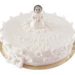 Tort na I Komunię Świętą z figurką chłopca z białymi kwiatuszkami